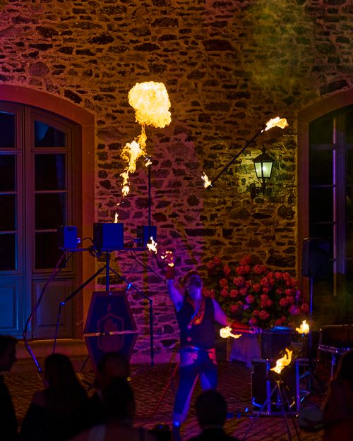 Feuershow mit brennenden Stäben und Flammen Projektoren